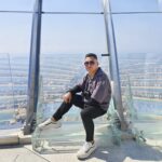 A panoramic 360-degree view of Dubai’s Palm Jumeirah from The View at the Palm Tower. The iconic palm-shaped island is clearly visible, surrounded by the turquoise waters of the Arabian Gulf, with luxury villas on the fronds and resorts on the crescent.