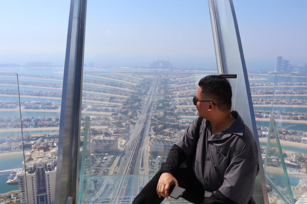 From high above the 52nd floor, the Palm Jumeirah unfolds like a dream—its palm-shaped design stretching gracefully into the Arabian Gulf, kissed by the golden glow of sunset.